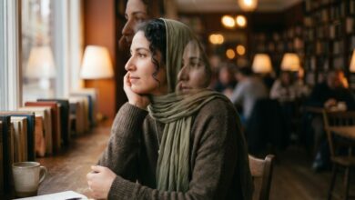 امرأة عربية في مقهى تتأمل بهدوء وتعبير صورتها يعكس التجربة الداخلية لمرضى الفصام